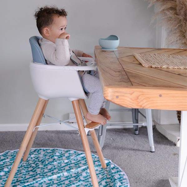 baby High Chair with a white seat, grey padded insert, light wood legs and footrest, and a white feeding tray