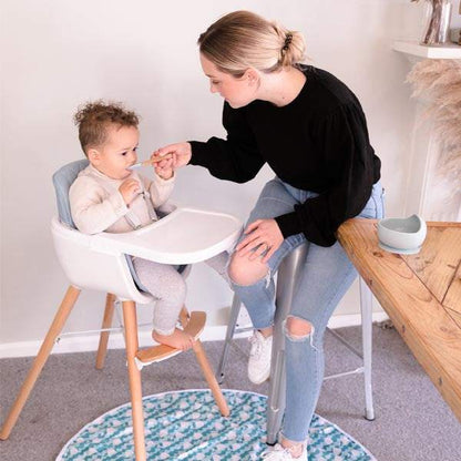 baby High Chair with a white plastic seat and tray, grey padded insert, wooden legs, and a footrest