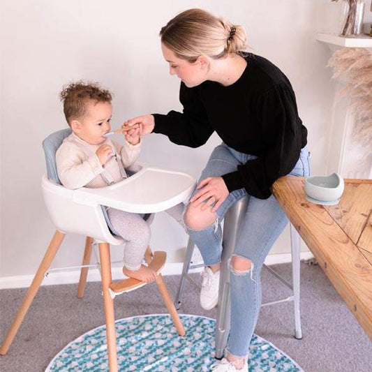 baby High Chair with a white plastic seat and tray, grey padded insert, wooden legs, and a footrest